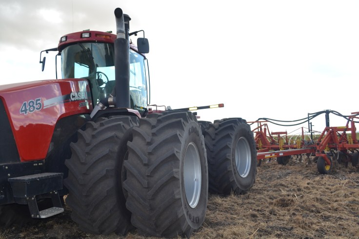A tractor pulling a cultivator in a field. 